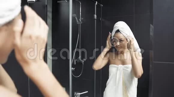 年轻女性在浴缸中洗澡后从头上取出毛巾自然干燥头发视频的预览图