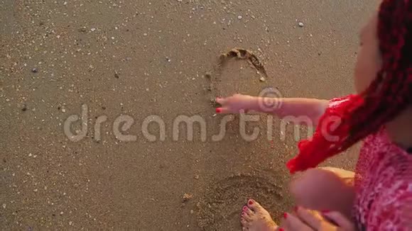 一个女人在沙子里写着共波这个词正在冲走视频的预览图