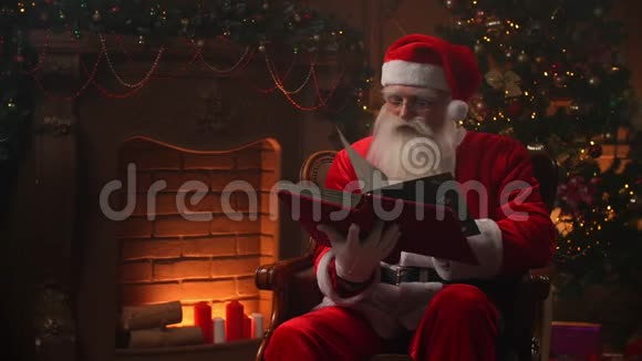 欢乐的正宗圣诞老人条款翻页红色封面书壁炉和圣诞树上视频的预览图