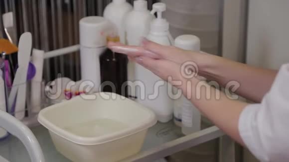 专业美容师在她的手上擦液体肥皂视频的预览图
