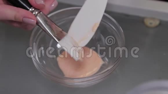 专业美容师女性在一个特殊的容器里搅动面具视频的预览图