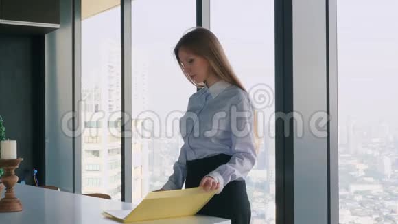 严肃的女商人站在办公室并将文件夹分开视频的预览图