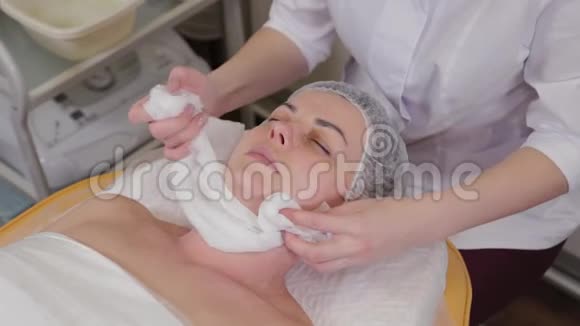 专业美容师女性从脸上移除湿巾视频的预览图