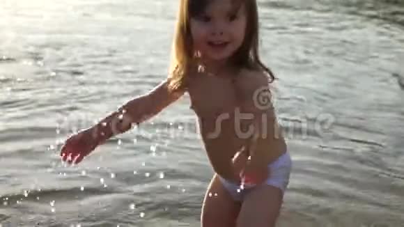 快乐的童年概念婴儿溅在水里泼水可爱的孩子在海滩上快乐地玩耍开心快乐视频的预览图