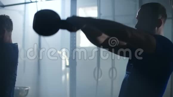 慢动作两个人在健身房用水壶铃做运动视频的预览图