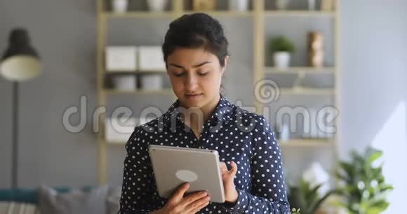 印度妇女在家庭办公室使用数字平板电脑在线应用程序视频的预览图