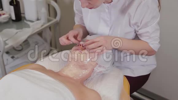 专业美容师女士用面部绷带覆盖面具视频的预览图