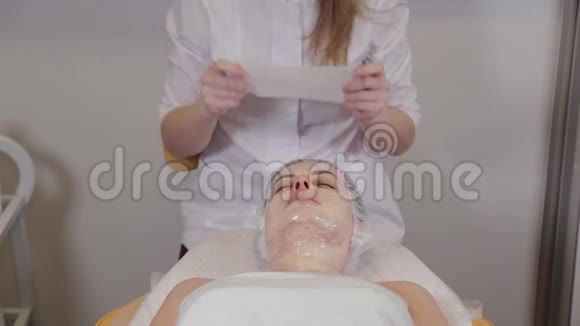 专业美容师女士用面部绷带覆盖面具视频的预览图