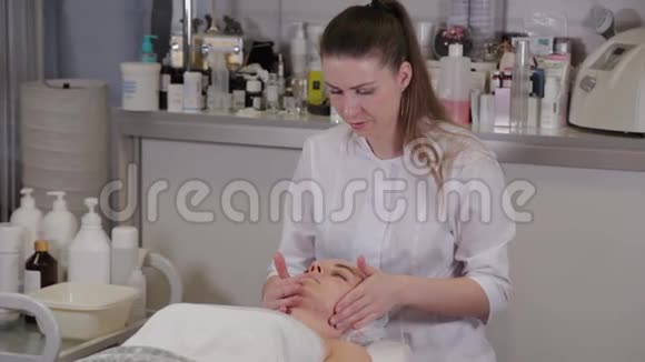 专业美容师女性为病人做面部按摩视频的预览图