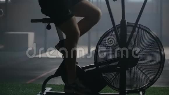 在健身自行车上做剧烈运动的人健身男子使用空气自行车进行健身运动视频的预览图