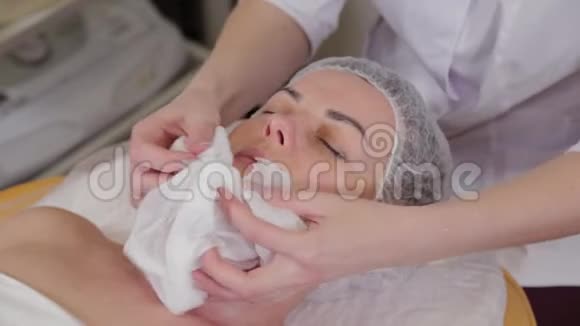 专业美容师女性从脸上移除湿巾视频的预览图