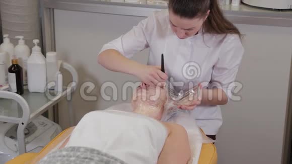 专业美容师女性在病人脸上戴面具视频的预览图