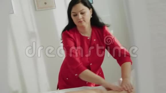 女性按摩治疗师按摩客户的腿视频的预览图