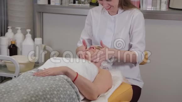 一位专业的美容师用液体肥皂病人的脸上同时按摩视频的预览图