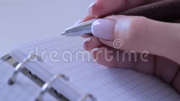 特写女性在老式笔记本管理器中写待办事项慢动作视频的预览图