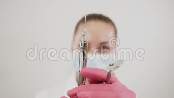 用手中的牙科工具给女牙医戴上面罩并从注射器中释放药物视频的预览图