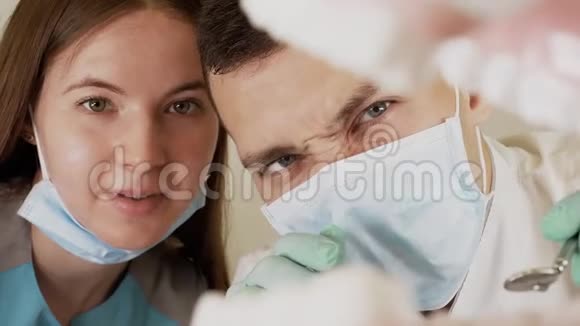 戴口罩的专业牙医手拿牙科工具检查口腔视频的预览图