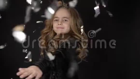 在五彩雨中翩翩起舞微笑的小女孩尽情享受激动孩子的现场情感视频的预览图