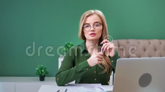 可爱的商业年轻女子戴着眼镜在现代工作场所摆姿势4k龙红相机视频的预览图