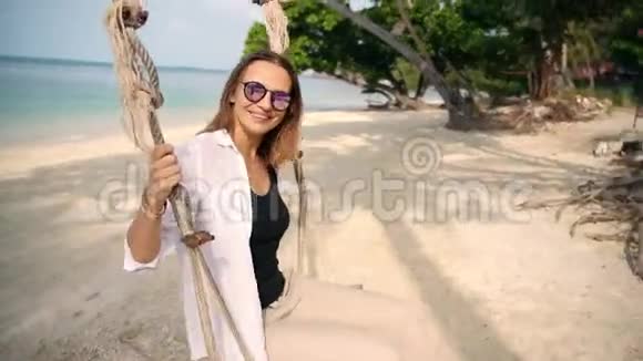 一位年轻女子在沙滩上荡秋千视频的预览图