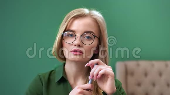 在办公室摆姿势戴眼镜的可爱女人的脸拍摄红鸦4k影院视频的预览图