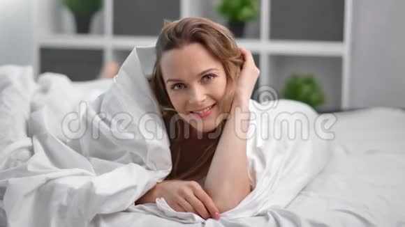 玩的诱惑女孩玩的开心躺在白色的床上拿着盖毯4k龙红相机视频的预览图