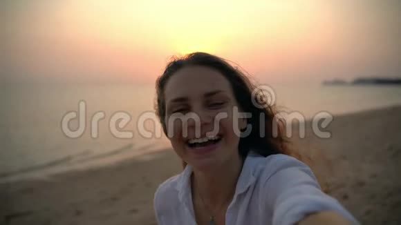 一个年轻开朗的女人在海滩上自拍视频的预览图
