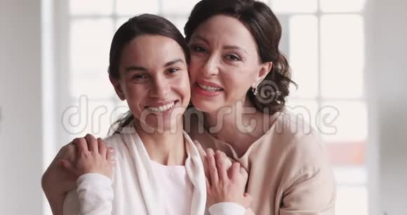 爱成熟的母亲拥抱年轻的女儿享受温柔肖像画视频的预览图