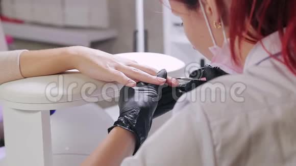 美容浴中的美甲医生正在客户指甲上涂胶视频的预览图