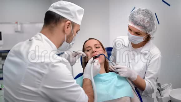 微笑妇女患者在牙齿治疗期间使用钻床在牙科4k龙红相机视频的预览图
