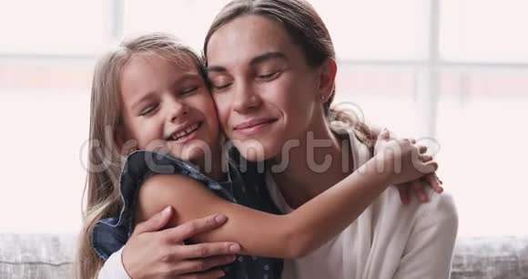 多情的年轻母亲拥抱可爱的孩子女儿享受温柔的时刻视频的预览图