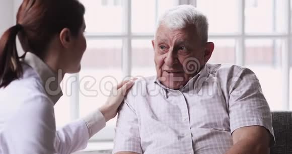 女医生照顾者在出诊期间支持老爷爷病人视频的预览图