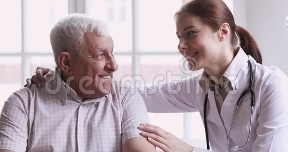 关爱年轻女医生护理员帮助支持快乐的老人视频的预览图