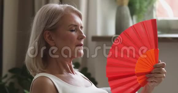 过热的老年妇女感到家里有一把热扇子视频的预览图