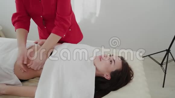 女性按摩治疗师对一个年轻女孩的胃进行按摩视频的预览图