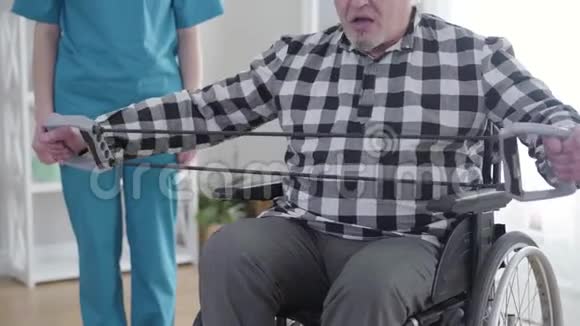 坐在轮椅上的一位白发苍苍的白种人作为一名职业护士站在视频的预览图