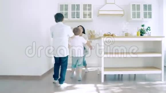 两个快乐的男孩在厨房里跑去妈妈吃早餐视频的预览图
