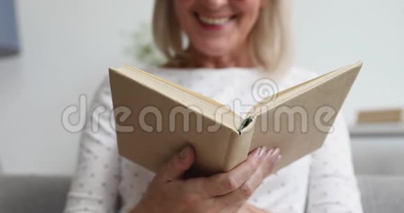 快乐的老妇人轻松地拿着看书近距离观看视频的预览图