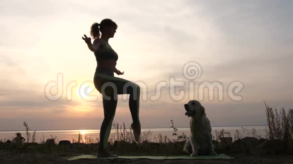 健身女性练习瑜伽平衡姿势日落视频的预览图