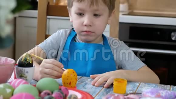 五岁小孩在厨房里给复活节彩蛋上色视频的预览图