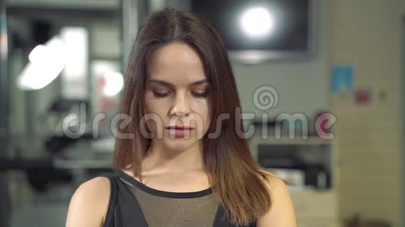 一幅宁静祥和的女人在现代办公室里看镜头的肖像视频的预览图