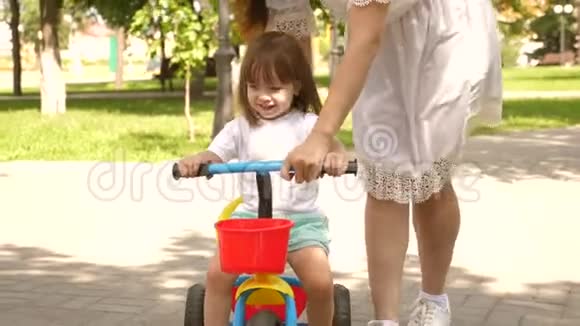 孩子学会骑自行车幸福家庭和童年的概念父母和小女儿在公园散步快乐视频的预览图