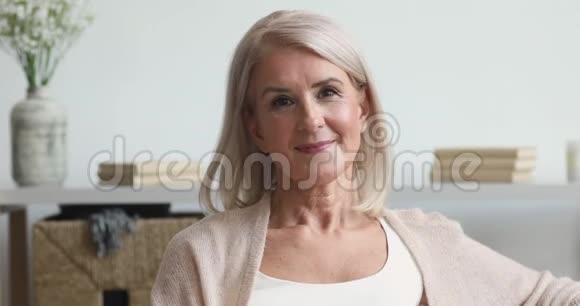 快乐的老年中年妇女在家看相机视频的预览图