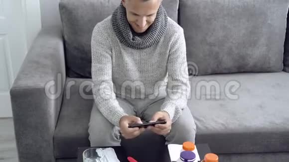 在家里生病时年轻人在智能手机上玩电脑游戏视频的预览图