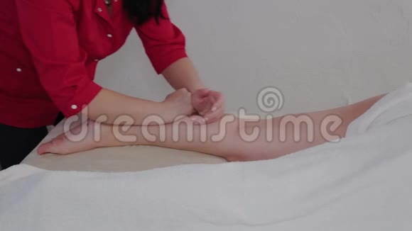 女性按摩治疗师按摩客户腿视频的预览图