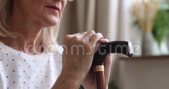 心烦意乱的老年妇女拿着拐杖感到悲伤特写视频的预览图