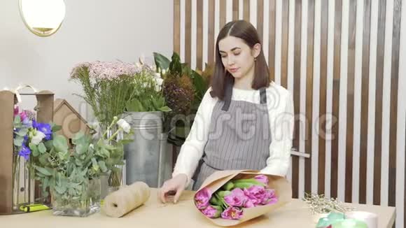 年轻女子花店用丝带系一束郁金香视频的预览图