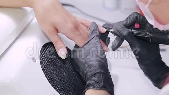 美容店里戴手套的医生处理病人指甲上的角质层视频的预览图