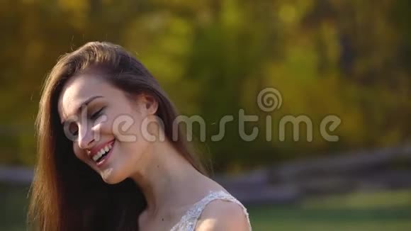 美丽的黑发新娘在秋天公园阳光下嬉戏的画像视频的预览图