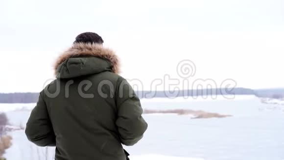 手持摇拍效果迷人的胡须男子站在户外冬季季节森林视频的预览图
